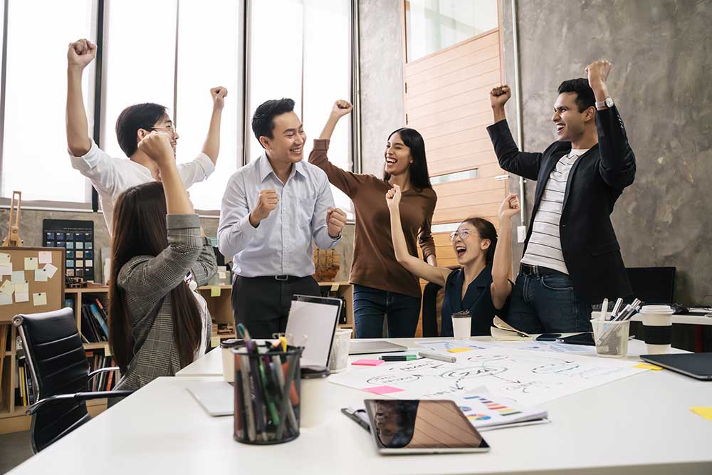 Group of middle-aged employees celebrating in the office environment 