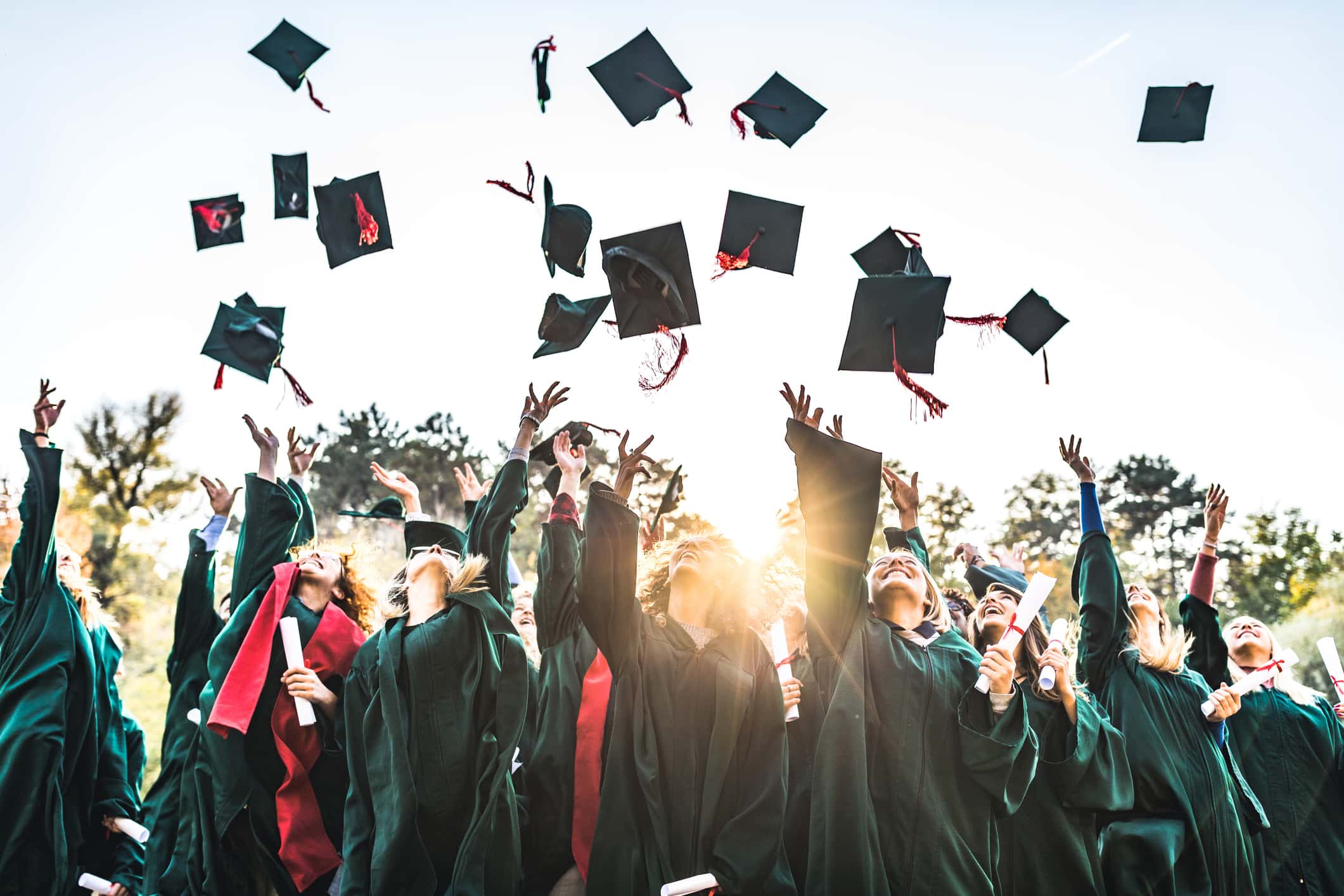 A group of graduate celebrating graduation and throwing their graduation cap